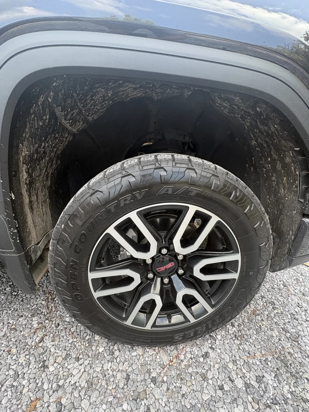 The GMC wheel and wheel well before cleaning